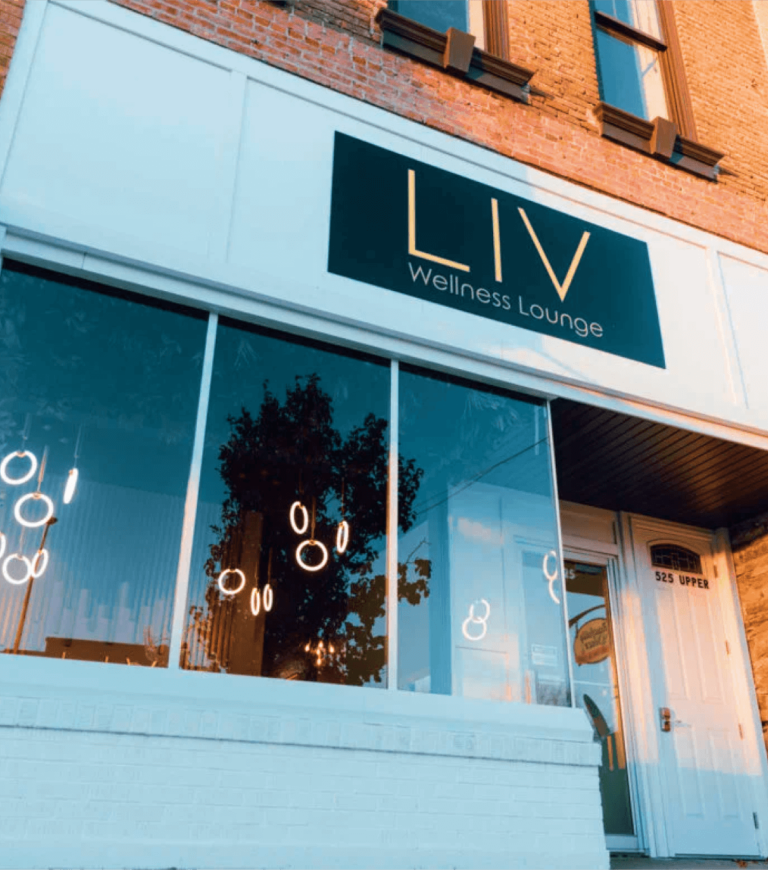 The storefront of a wellness lounge called LIV, with a black sign and large windows.