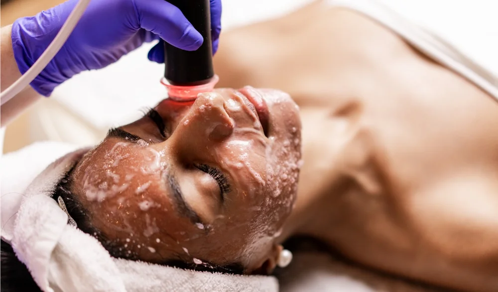 Healthcare professional performing a facial treatment on a female patient at LIV Wellness Lounge.