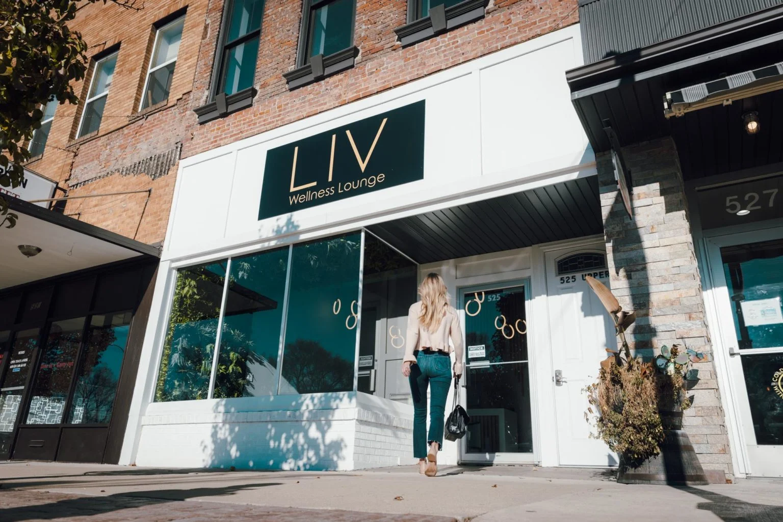 Exterior view of LIV Wellness Lounge with a woman entering the building.