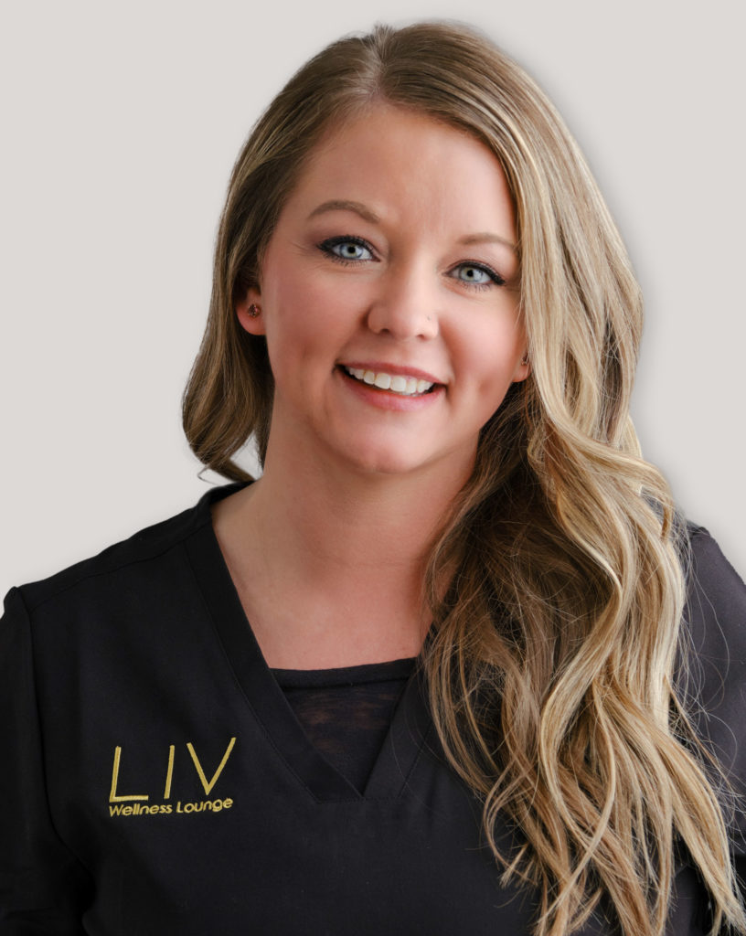 A professional woman named Molly Sampat smiles warmly while wearing a LIV Wellness Lounge uniform. She has wavy blonde hair and presents a friendly, approachable demeanor.