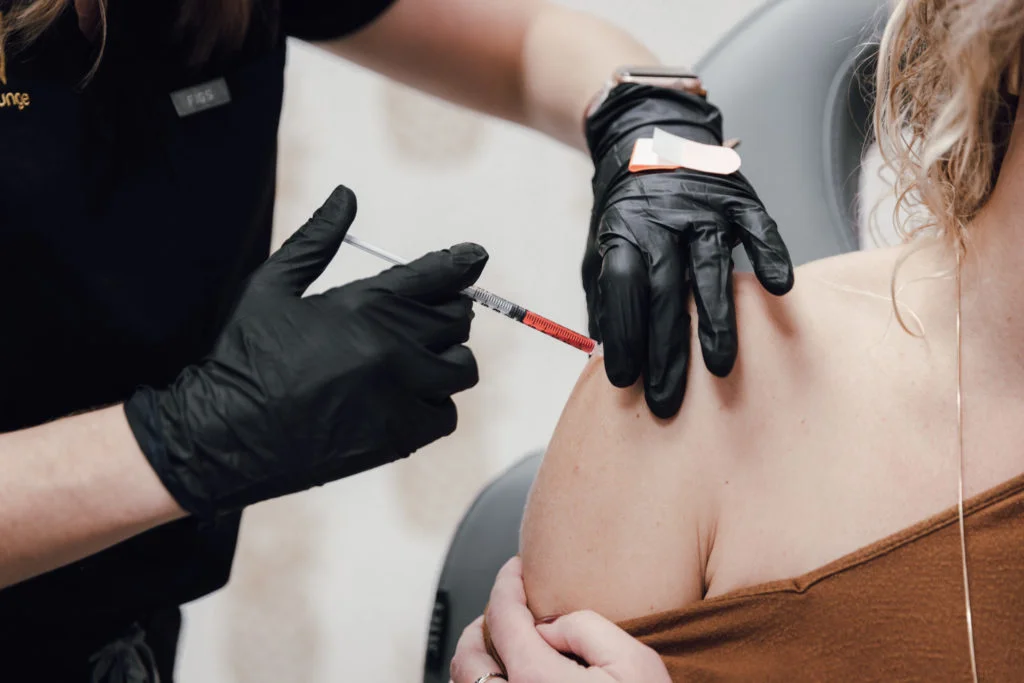 Healthcare professional administering an injection into a patient's arm at LIV Wellness Lounge.