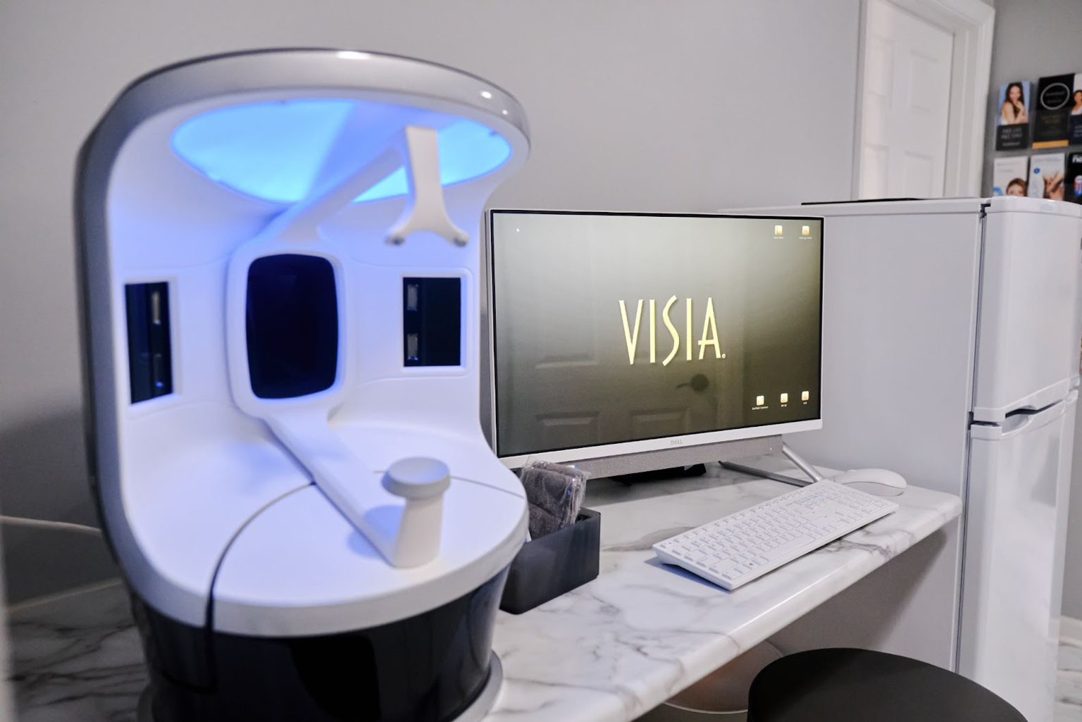 A VISIA skin analysis machine is set up next to a computer screen displaying the VISIA logo at LIV Wellness Lounge. The setup is clean and professional, ready for use in personalized skin diagnostics.