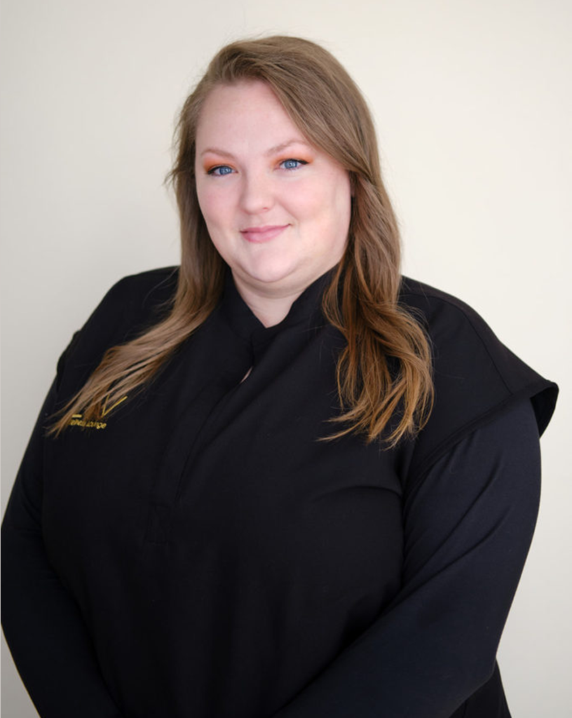 Portrait of Andrea smiling warmly, wearing a black uniform with the LIV Wellness Lounge logo.